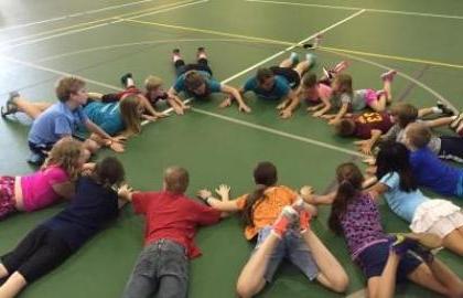 elementary students lying on gym floor in circle